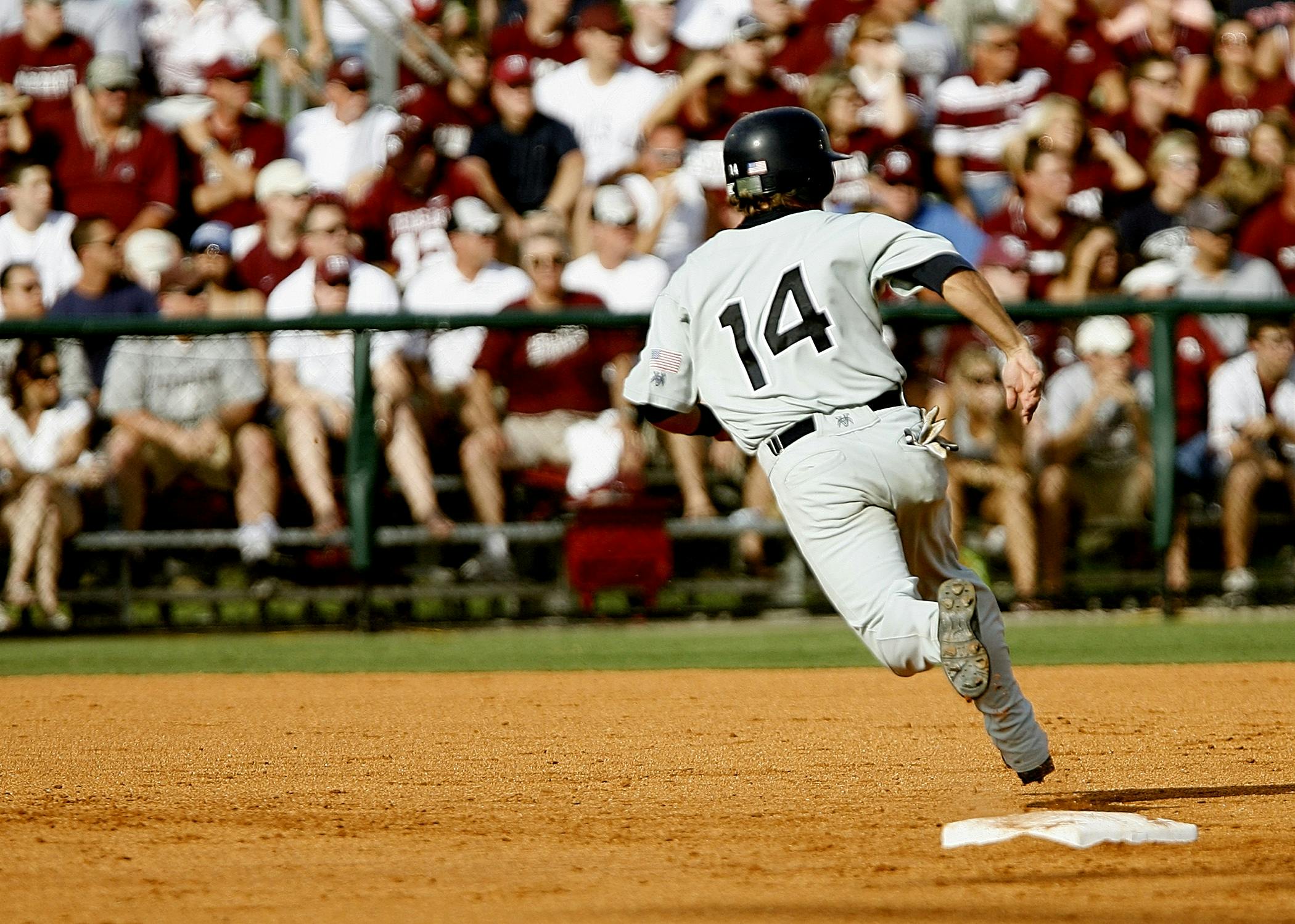 Baseball player number 14 chasing goal on baseball field